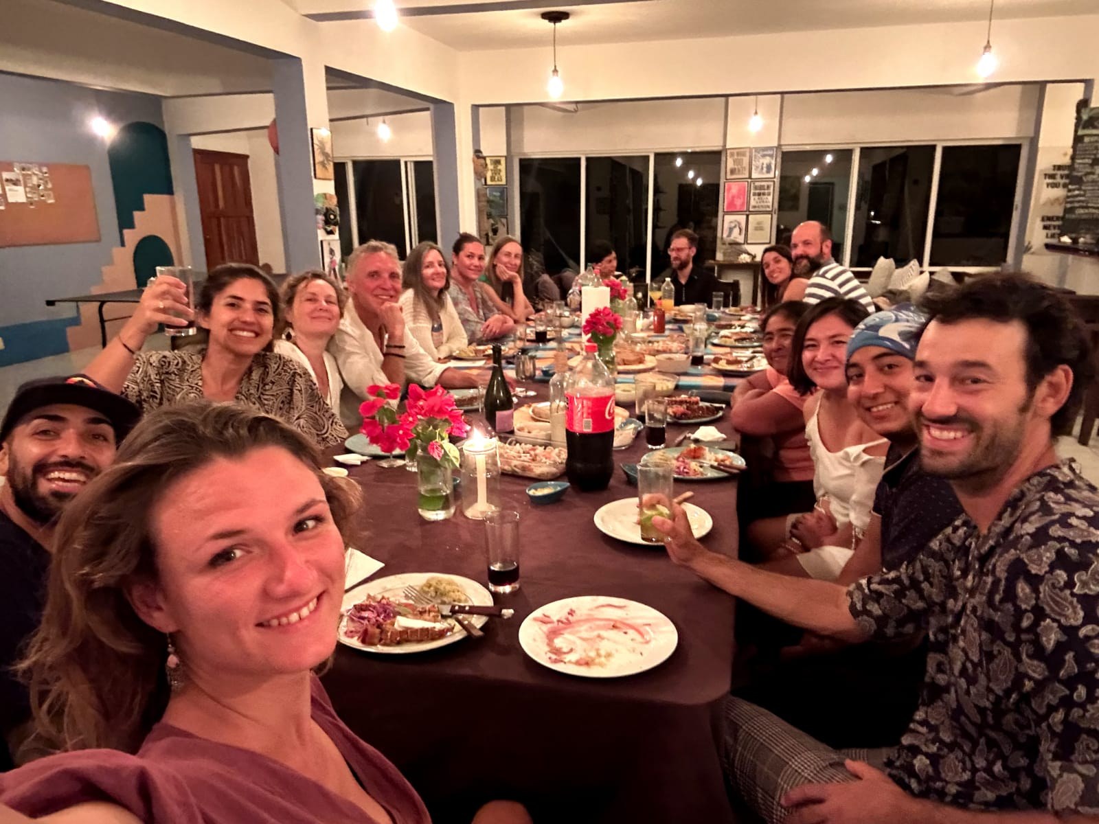 Guests and volunteers sharing dinner at the long table at Casa Pronoia